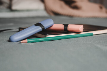 Notebook, pencil, headphones, glasses, camera, placed on a gray background.