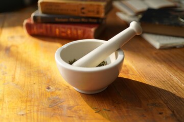 Mortar and pestle for herbs and spices on wooden table in natural light photo