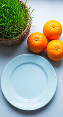 Fresh Oranges and Empty Plate with Green Grass Background