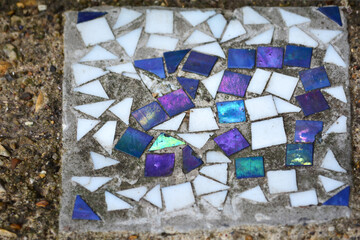 Bright blue and purple tiles are arranged in a striking mosaic pattern among scattered white pieces...