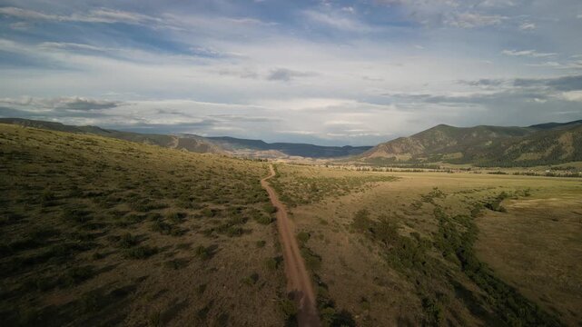 Aerial over dirt road in Creede Colorado rolling hills in San juan Mountains in summer