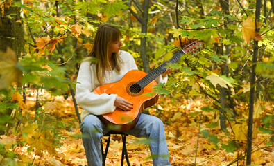 young woman with guitar in autumn