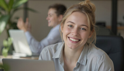 Smiling young woman interacts with colleagues online via laptop. Engaged in video conference, fostering team collaboration, connection in modern office setting. Happy expression reflects successful