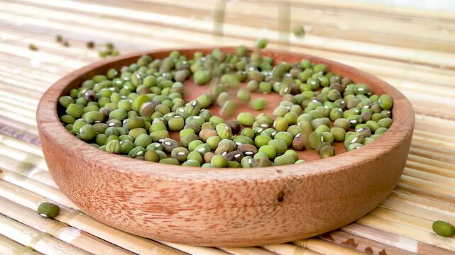 mung beans scattered in a bowl on a bamboo mat