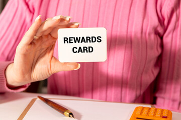 Girl holding a card with the text Rewards Card