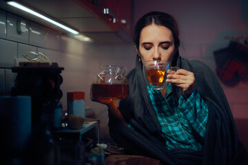 Sick Woman Pouring Some Healing tea from the Tea Pot. Unhappy suffering patient trying some self...