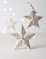Obraz premium Three White Metal Star Ornaments on White Background with Bokeh Lights Holiday Season