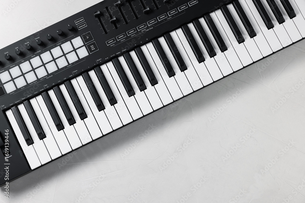 Poster one portable midi keyboard on white table, top view. space for text