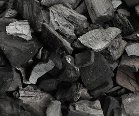Pieces of black coals as background, top view