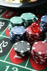 Casino chips and die on roulette table, closeup