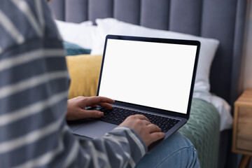Woman having online consultation with doctor via laptop on bed at home, closeup
