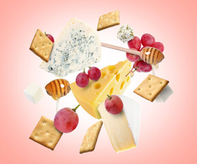 Cheese board products in air on pink gradient background. Different types of cheese, grapes, crackers and honey