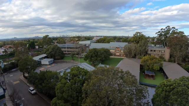 View of the Sydney city skyline from far and Ashfield school playground 