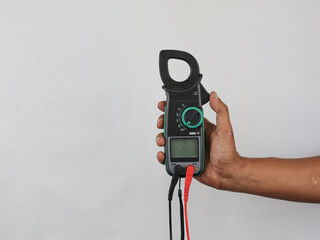 Digital clamp meter held by hand to test current and voltage in electronics isolated on white...