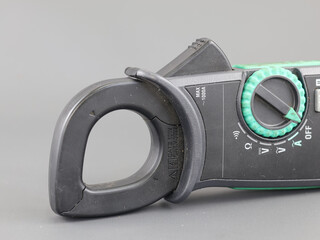 Close up digital clamp meter isolated on grey Background.