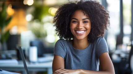 Young woman with curly hair smiling in a modern office setting