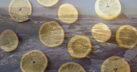 Scattering translucent lemon slices across rocky coastline, revealing foamy ocean waves
