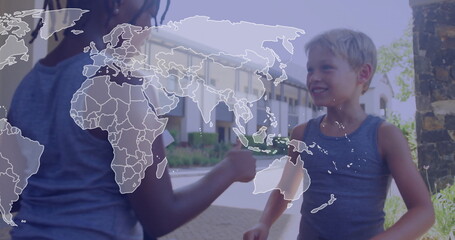 Exchanging kids wearing gray tank tops fist-bumping in suburban courtyard, with world map overlay