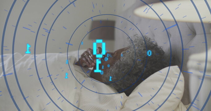 Holding smartphone senior woman reclining on bed in master bedroom, with digital interface overlay