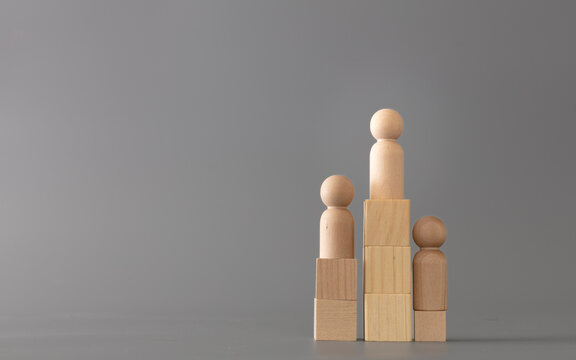 Wooden Human standing on podium with ranking for winner business and sport competition concept, on grey background.