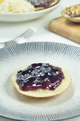 Serabi pancakes topped with blueberry jam, a traditional Indonesian snack