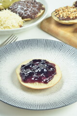 Serabi pancakes topped with blueberry jam, a traditional Indonesian snack