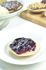 Serabi pancakes topped with blueberry jam, a traditional Indonesian snack