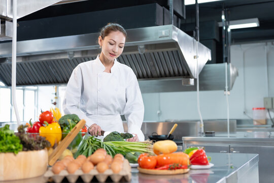 Female Chef Preparing Fresh Vegetables in a Commercial Kitchen, Professional Cook Chopping Broccoli for Healthy Meal, Asian Woman Chef Working in Modern Restaurant Kitchen