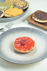 Serabi pancakes topped with strawberry jam, a traditional Indonesian snack