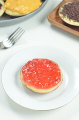 Serabi pancakes topped with strawberry jam, a traditional Indonesian snack