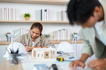 Obraz premium Creative Teamwork in Architecture. Young professionals designing sustainable model.