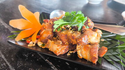 Crispy pork belly stir-fried with chili and salt on white plate, Thai spicy food close-up, delicious Asian cuisine concept
