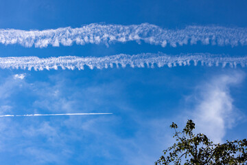 Multiple jet streams across blue sky
