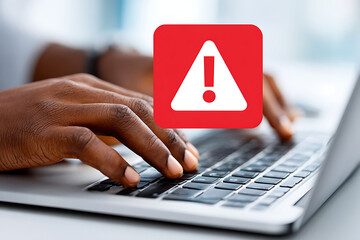 Person Typing on Laptop With Warning Symbol Displayed, Indicating a Potential Alert or Error in a Digital Workspace