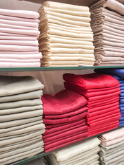 Hijab cloth on a shop shelf. Satin, cotton, and silk fabrics are displayed on shelves, arranged by color and gradation. Textured backgrounds in various colors. Graphic Resources. Negative space.
