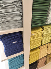 Hijab cloth on a shop shelf. Satin, cotton, and silk fabrics are displayed on shelves, arranged by color and gradation. Textured backgrounds in various colors. Graphic Resources. Negative space.