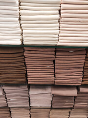 Hijab cloth on a shop shelf. Satin, cotton, and silk fabrics are displayed on shelves, arranged by color and gradation. Textured backgrounds in various colors. Graphic Resources. Negative space.
