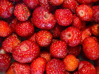 Strawberries photographed from an upper angle. The frame is filled with a red berry.