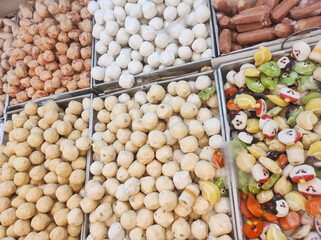 Top-angle shot of stew ingredients or sukiyaki dish. Stew ingredients consist of cheese dumplings, soup dumplings, fish balls, shrimp and crab balls, Chikuwa. Cooking ingredients in the supermarket.