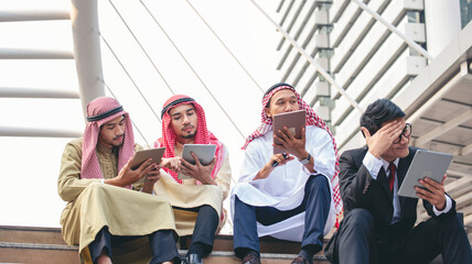 Fototapeta premium Multicutural Group of people diversity men talking look at digital tablet smile face. Empowering communication happy multiethnic muslim man and businessman team partner discussion in city street