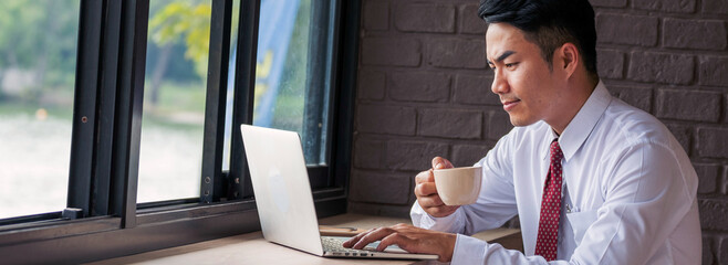 Banner Man hands typing laptop notebook holding coffee cup outside office. Panorama man hands using...