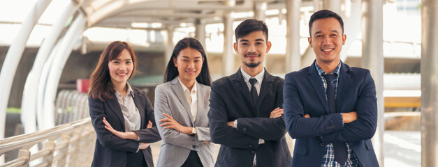 Group of business people asian team partners walking in city happy together. Leader executive men standing at modern urban city with confident teamwork. Portrait diversity businesspeople teamwork