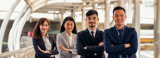 Group of business people asian team partners walking in city happy together. Leader executive men standing at modern urban city with confident teamwork. Portrait diversity businesspeople teamwork