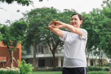 Obraz premium Mature woman doing stretching exercises in park Healthy lifestyle concept Copy space