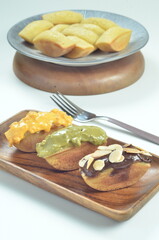 Pukis cake with various toppings of chocolate, cheese, peanuts, and matcha, a traditional Indonesian snack
