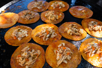 Las gorditas o chalupas mexicanas se están haciendo en el comal en un restaurante callejero.