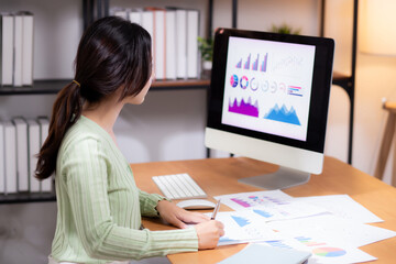 Young asian businesswoman planning and strategy about finance looking graph and chart of report marketing in home office, business woman analyzing financial and revenue for success, business concept.