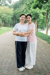 Mother and daughter embrace in a park enjoying a moment of connection and love in nature
