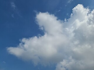 Blue sky with fluffy white clouds, perfect for backgrounds, weather concepts, or serene nature themes. Captures a bright, clear day.