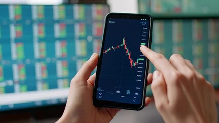 A person's hands holding a smartphone displaying a stock market chart for financial analysis. - Powered by Adobe